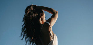 Woman standing in the sun with a clear sky ahead of her